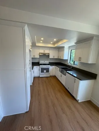 a kitchen with stainless steel appliances granite countertop a stove a sink and a refrigerator