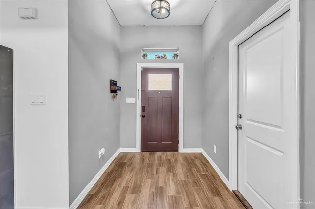 a view of a hallway with wooden floor and a bathroom