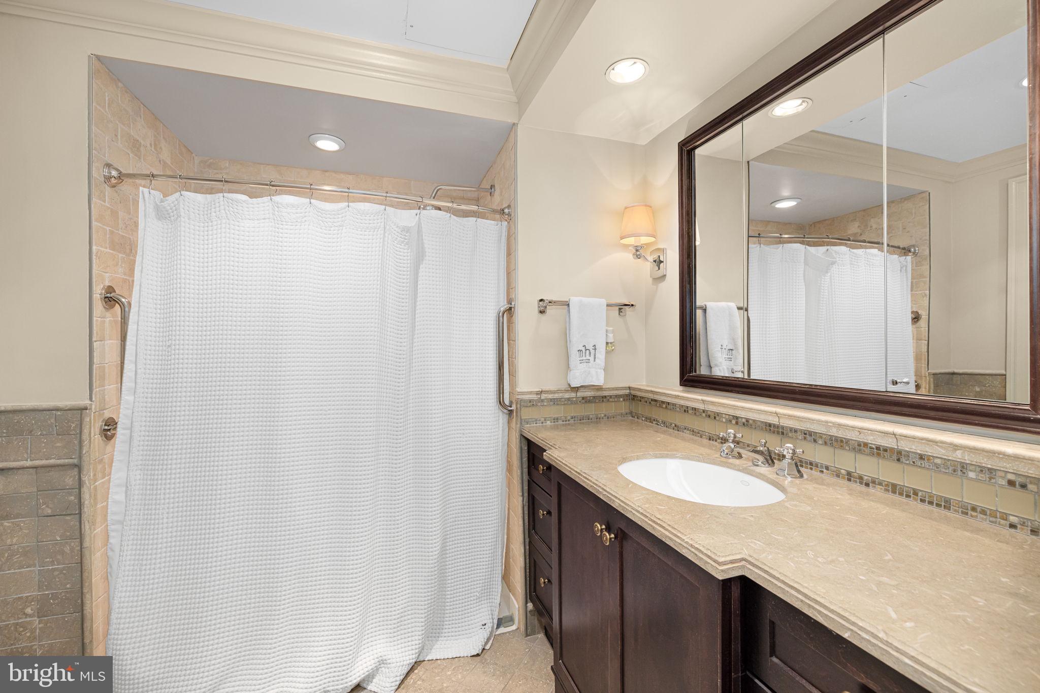 2700 Calvert Street Northwest, Unit 817 Washington, DC 20008 - Photo 46 of 64 a bathroom with a granite countertop sink and a mirror