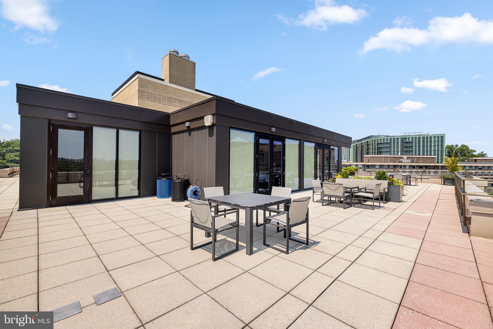 2700 Calvert Street Northwest, Unit 817 Washington, DC 20008 - Photo 56 of 64 a view of a patio with dining table and chairs with wooden floor and fence