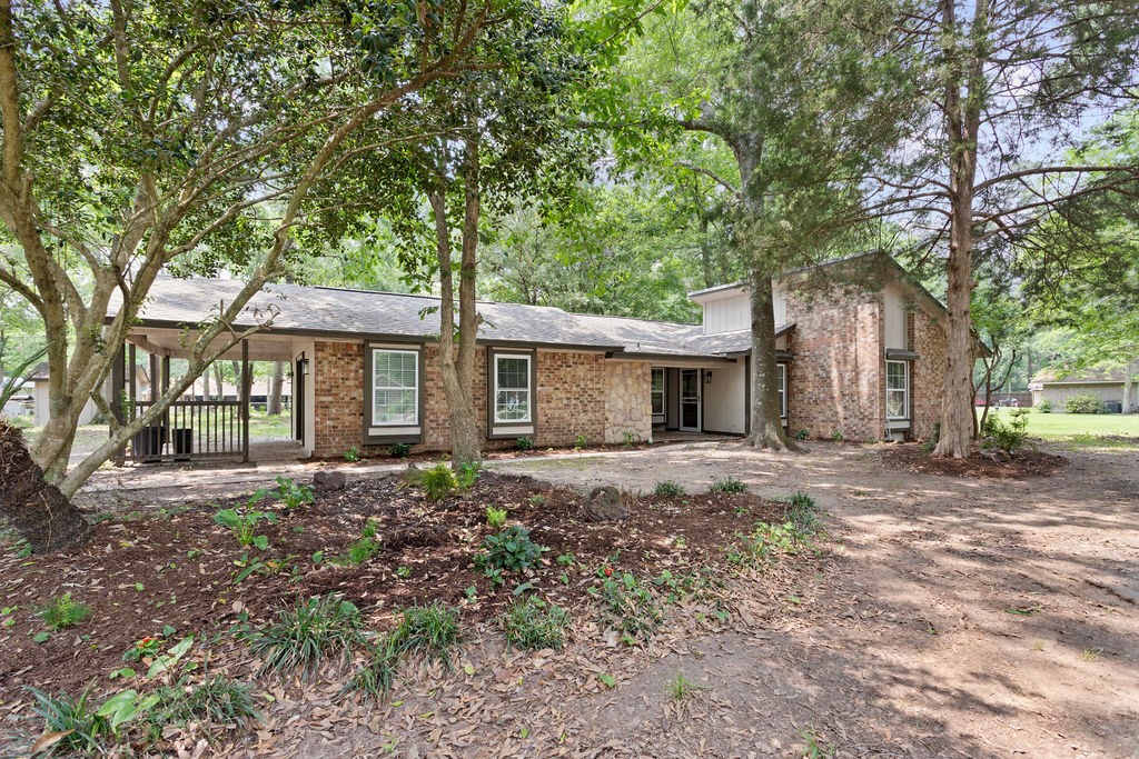 15050 Cardinal Trail Conroe, TX 77302 - Photo 39 of 44 a front view of a house with a garden