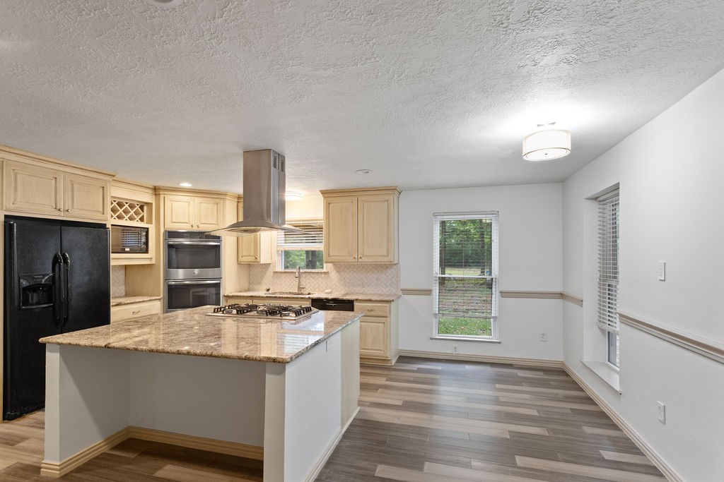 15050 Cardinal Trail Conroe, TX 77302 - Photo 6 of 44 a kitchen with stainless steel appliances granite countertop a stove a sink and a refrigerator