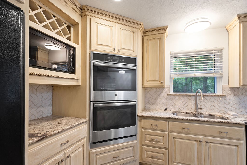 15050 Cardinal Trail Conroe, TX 77302 - Photo 9 of 44 a kitchen with granite countertop stainless steel appliances and stove top oven