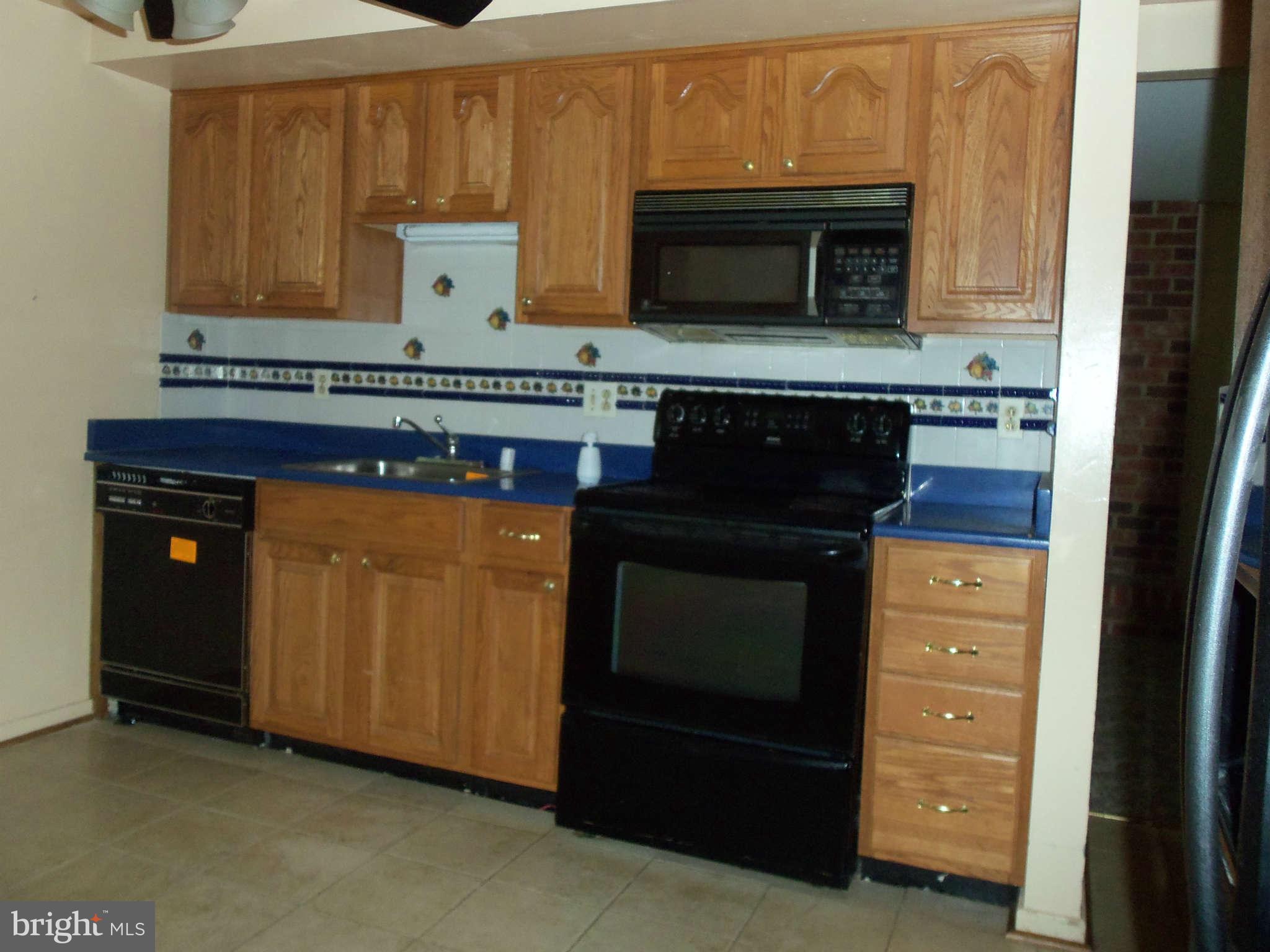 9619 Winands Road Randallstown, MD 21133 - Photo 6 of 20 a kitchen with stainless steel appliances granite countertop a stove and a microwave