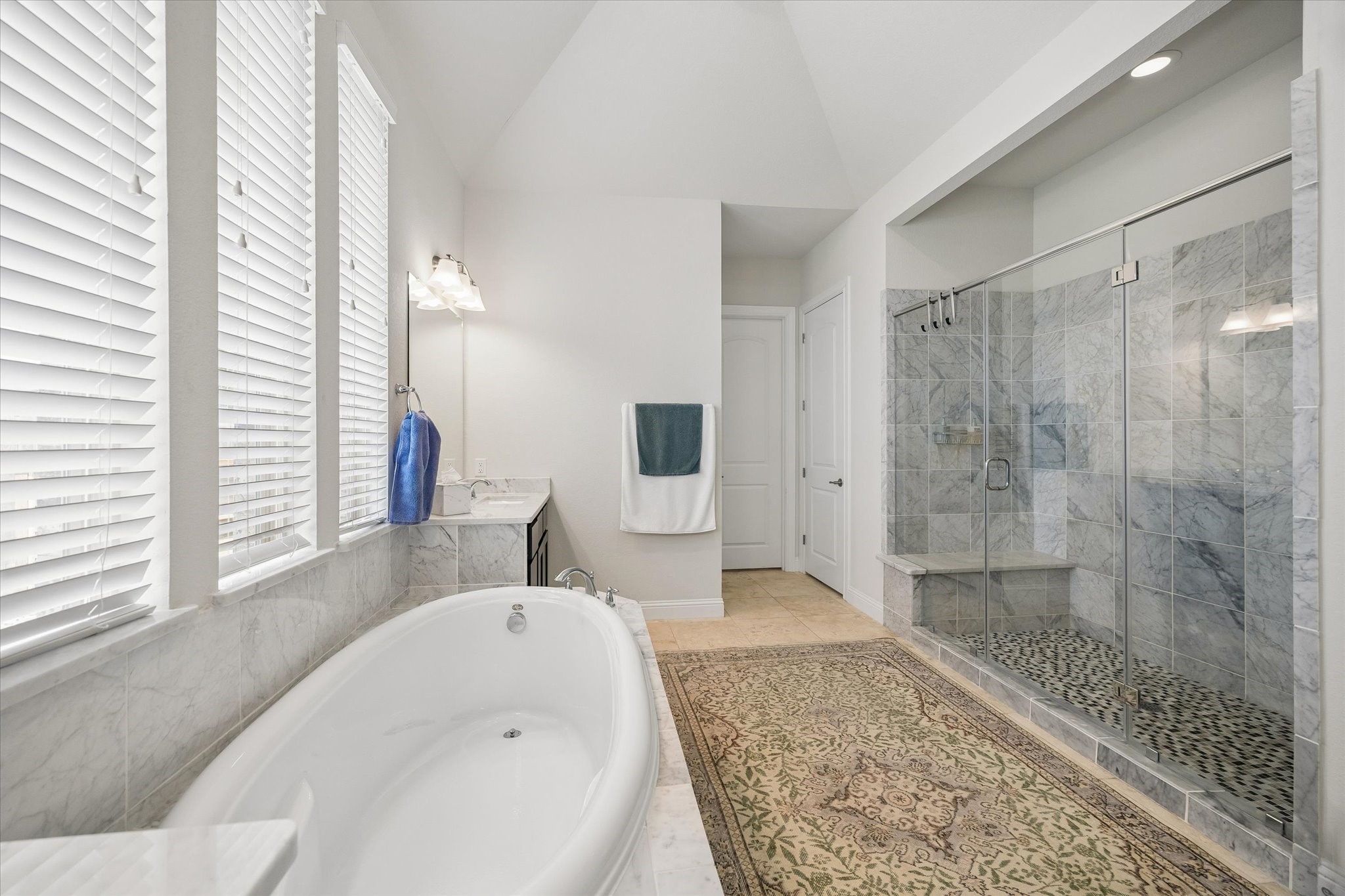 7418 Kearney Hill Lane Spring, TX 77389 - Photo 13 of 35 The primary en-suite bathroom is spacious and tasteful. A deep soaking tub is centered under the windows. An oversized walk-in marble tile shower enhances the indulgent feel of the spa-like space. The laundry room conveniently connects to the primary bath.