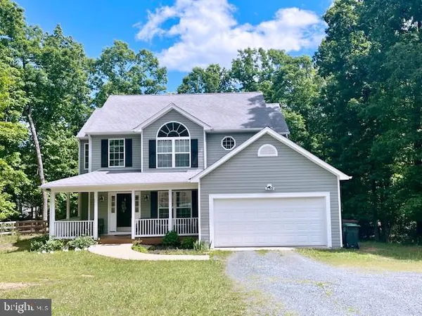 a front view of a house with a yard and trees