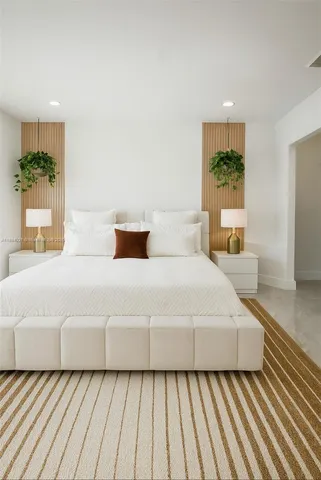 a bedroom with a large bed and a potted plant