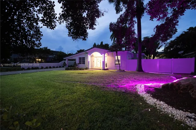 a view of a yard with plants and a fountain