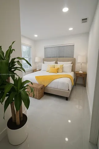 a bedroom with bed and a potted plant