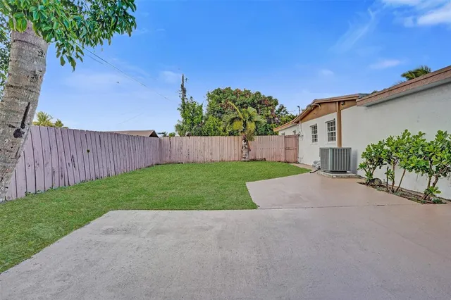 front view of a house with a yard and potted plants