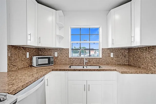 a kitchen with stainless steel appliances granite countertop a sink a stove and a granite counter tops