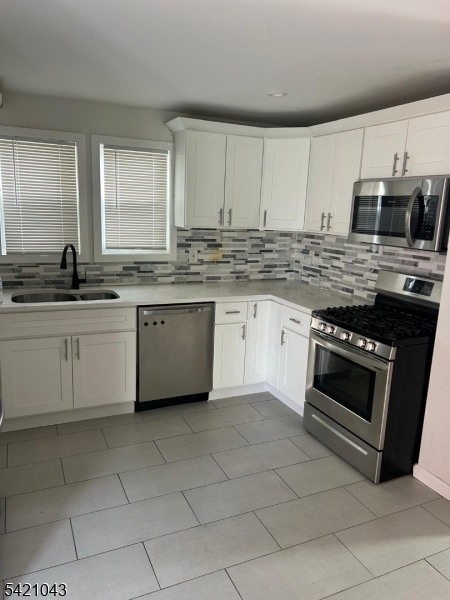 1210 Roselle Street Linden, NJ 07036 - Photo 3 of 15 a kitchen with stainless steel appliances a stove sink and microwave