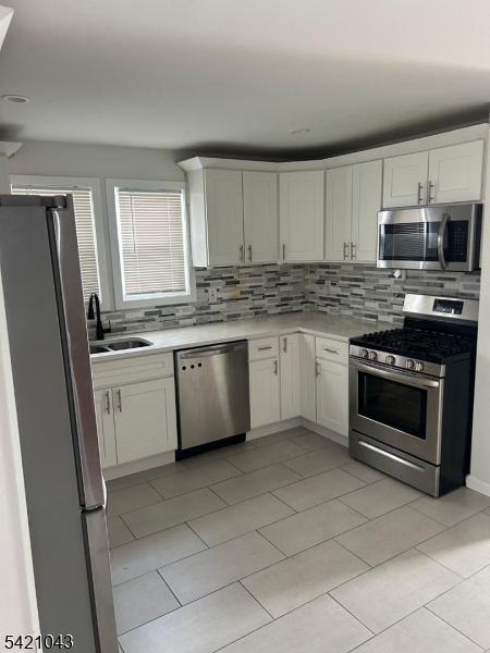 1210 Roselle Street Linden, NJ 07036 - Photo 4 of 15 a kitchen with stainless steel appliances granite countertop a stove a sink and a refrigerator