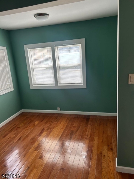 1210 Roselle Street Linden, NJ 07036 - Photo 7 of 15 a view of an empty room with wooden floor and a window