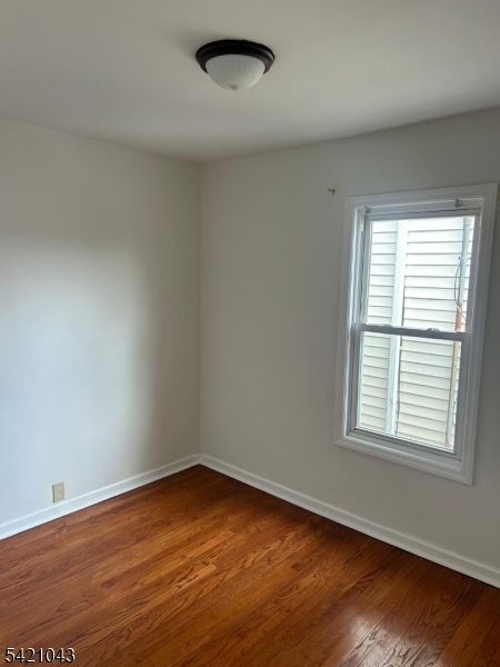 1210 Roselle Street Linden, NJ 07036 - Photo 8 of 15 an empty room with wooden floor and windows