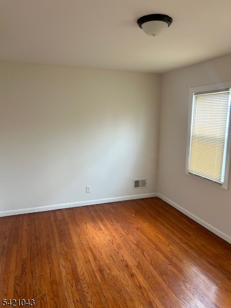 1210 Roselle Street Linden, NJ 07036 - Photo 10 of 15 an empty room with wooden floor and windows