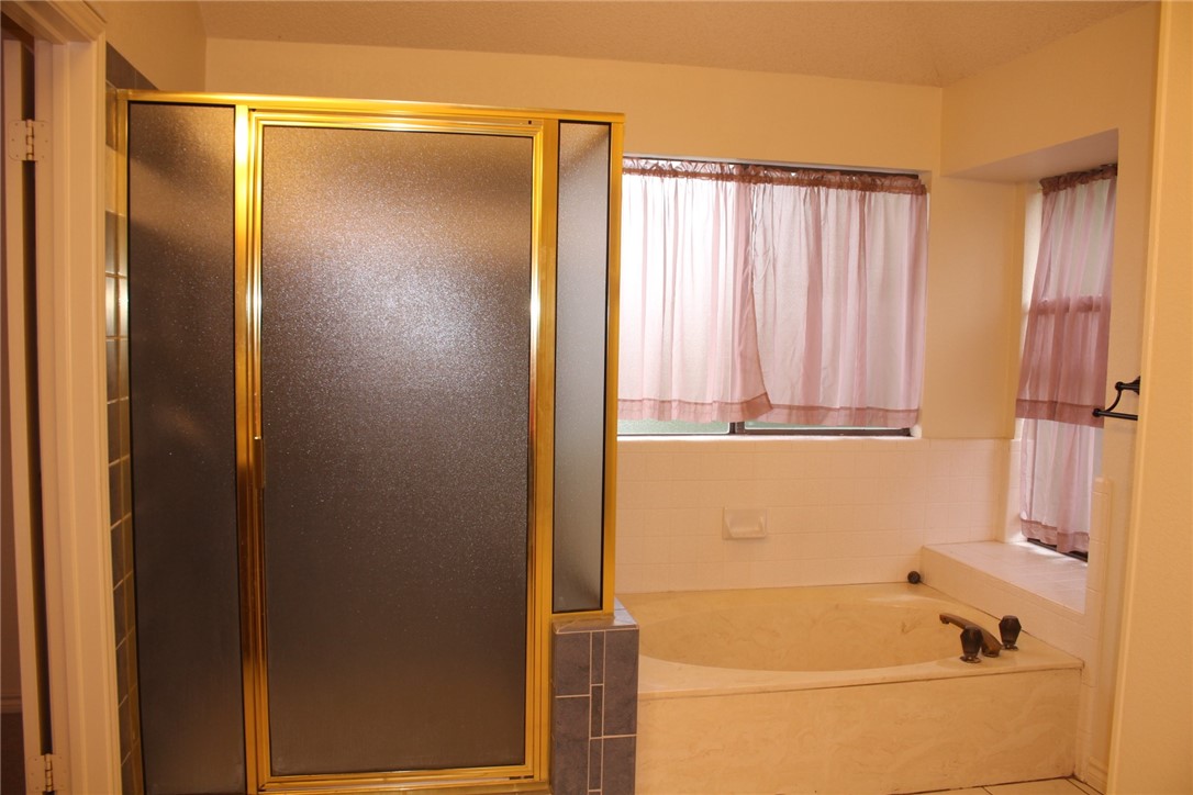 2141 Surrender Avenue Austin, TX 78728 - Photo 27 of 38 a bathroom with a bathtub and a shower