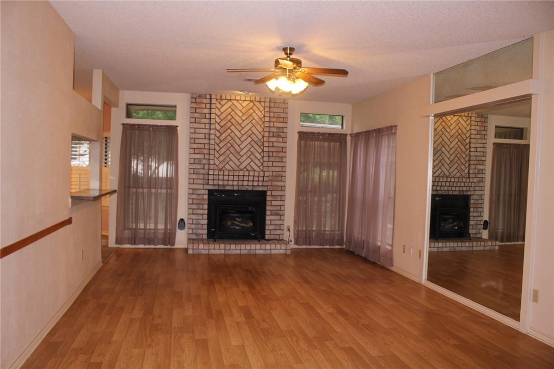 2141 Surrender Avenue Austin, TX 78728 - Photo 9 of 38 a view of a livingroom with a fireplace wooden floor and staircase