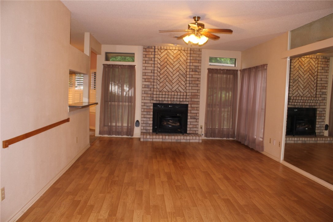2141 Surrender Avenue Austin, TX 78728 - Photo 10 of 38 a view of an empty room with wooden floor fireplace and a window