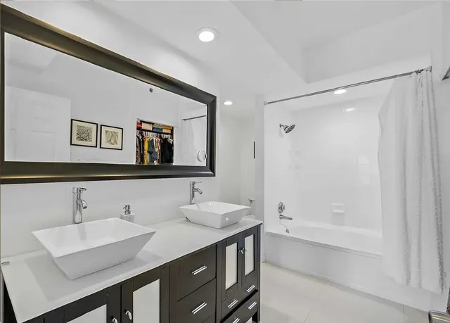 a bathroom with a tub a sink and mirror