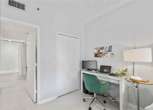 a view of a workspace with furniture and a window