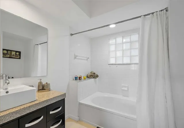 a bath room with a sink and a bath tub