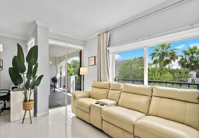 a living room with furniture a large window with kitchen view