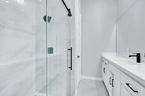 a bathroom with a double vanity sink a mirror and a shower