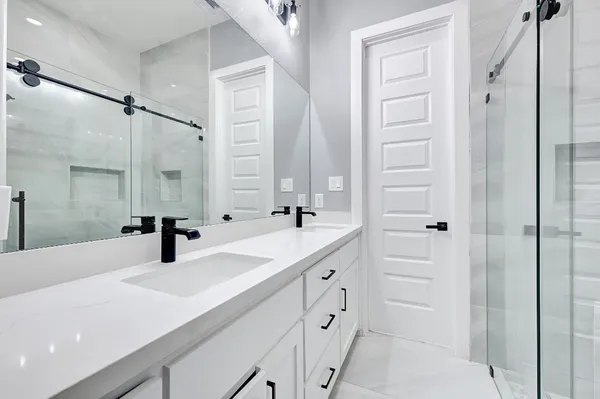 a bathroom with a double vanity sink a mirror and shower