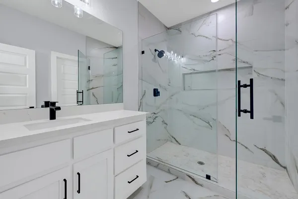 a bathroom with a shower sink and mirror