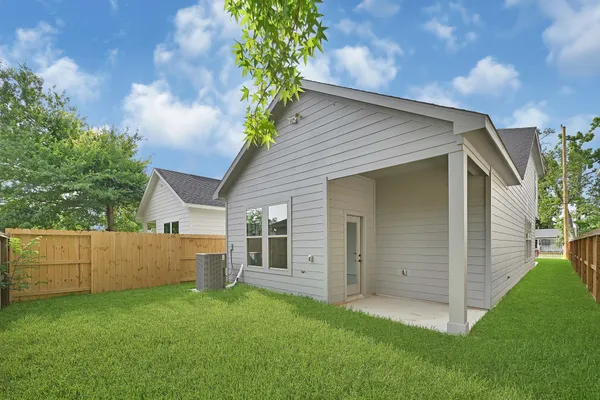 a view of backyard with potted plants and large tree