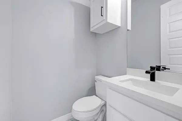 a bathroom with a sink a toilet and mirror