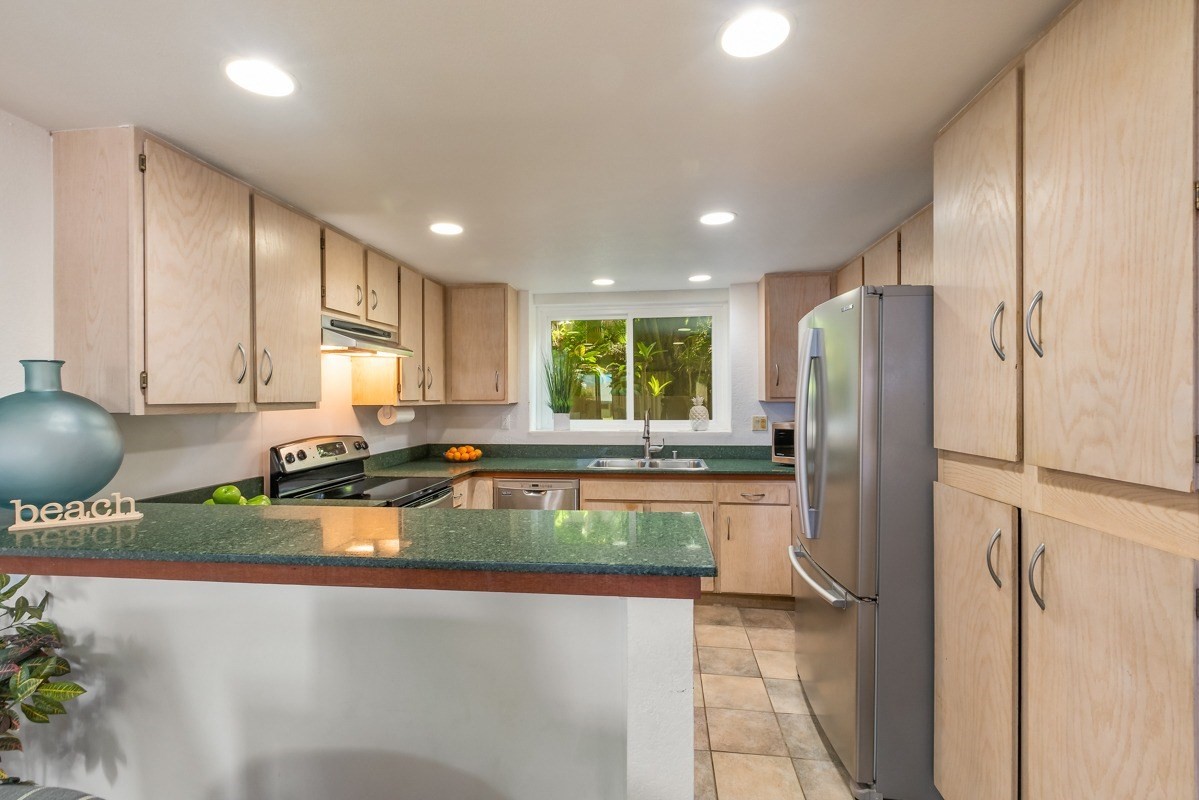 1661 Pee Road, Unit IIA101 Koloa, HI 96756 - Photo 11 of 28 a kitchen with a refrigerator and a sink