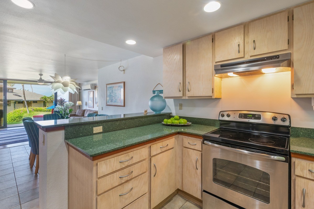 1661 Pee Road, Unit IIA101 Koloa, HI 96756 - Photo 13 of 28 a kitchen with granite countertop a sink stove and cabinets