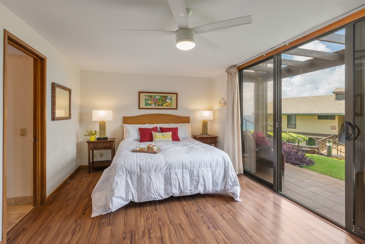 1661 Pee Road, Unit IIA101 Koloa, HI 96756 - Photo 16 of 28 a bedroom with a balcony a bed and wooden floor