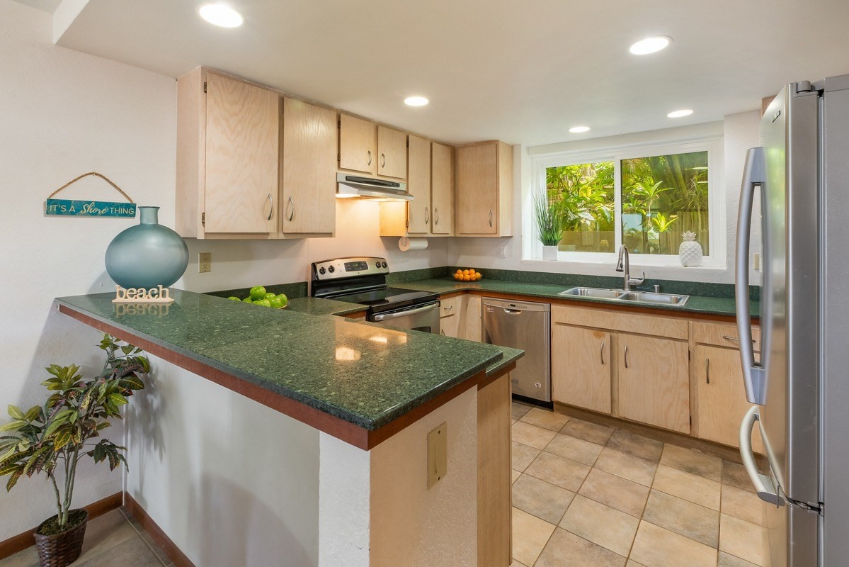 1661 Pee Road, Unit IIA101 Koloa, HI 96756 - Photo 10 of 28 a kitchen with stainless steel appliances granite countertop a sink counter space cabinets and a window