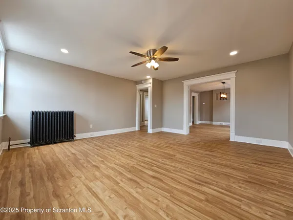a view of a livingroom with a ceiling fan and wooden floor