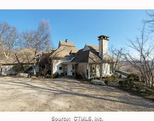 a front view of a house with a snow in the background