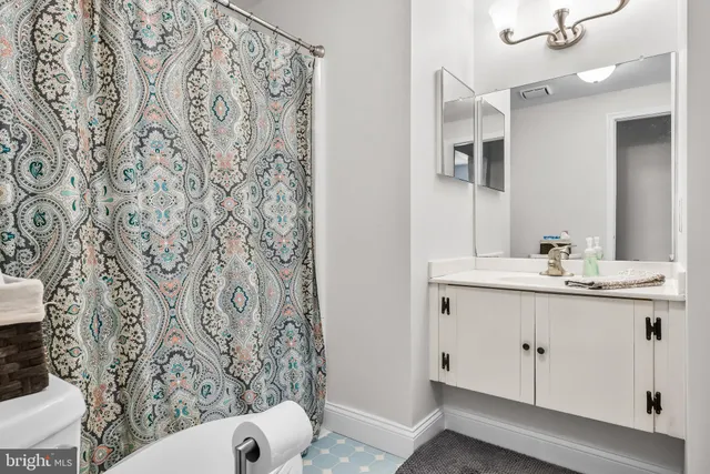 a bathroom with a sink and mirror with toilet
