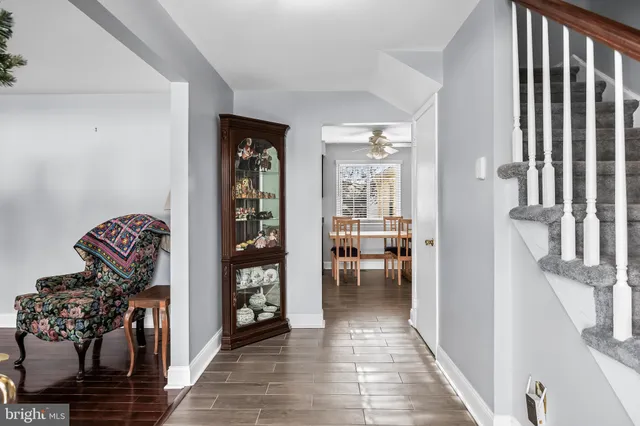 a view of a hallway to a livingroom with wooden floor and furniture