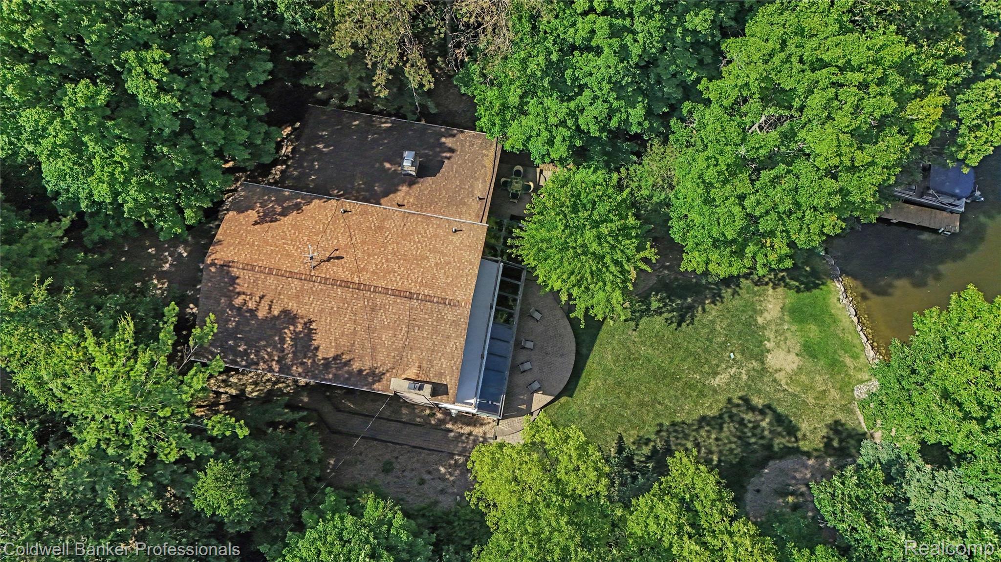 3583 Mitchell Road Metamora, MI 48455 - Photo 58 of 58 Waterfront property featuring extensive mature tree coverage, a private dock, and a patio area