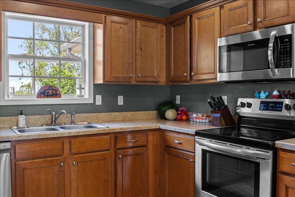 109 Bessie Clark Road Erin, TN 37061 - Photo 11 of 43 a kitchen with stainless steel appliances granite countertop a sink stove and cabinets