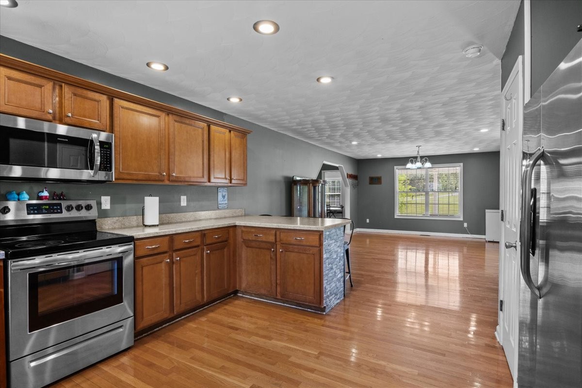 109 Bessie Clark Road Erin, TN 37061 - Photo 13 of 43 a kitchen with stainless steel appliances granite countertop wooden cabinets a stove a sink and a microwave