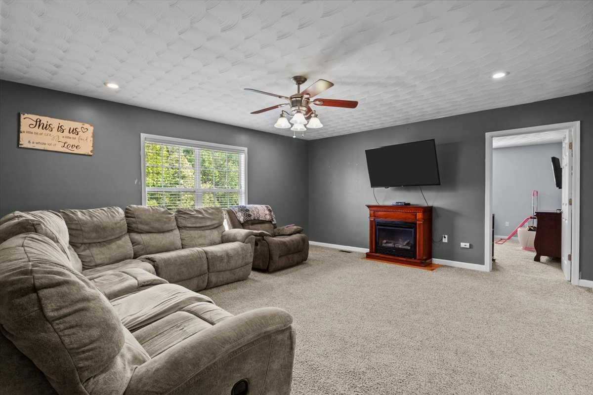 109 Bessie Clark Road Erin, TN 37061 - Photo 15 of 43 a living room with furniture a fireplace and a flat screen tv