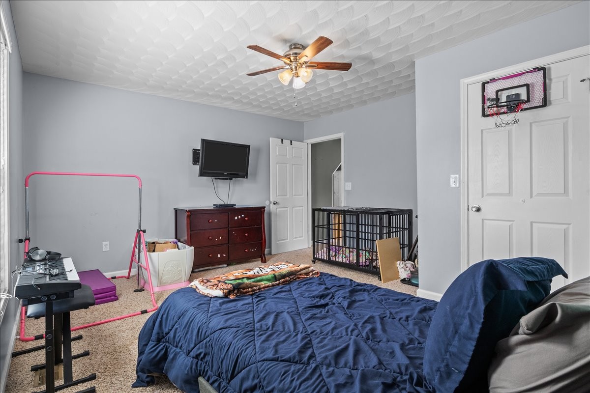 109 Bessie Clark Road Erin, TN 37061 - Photo 24 of 43 a bedroom with a bed and a chandelier