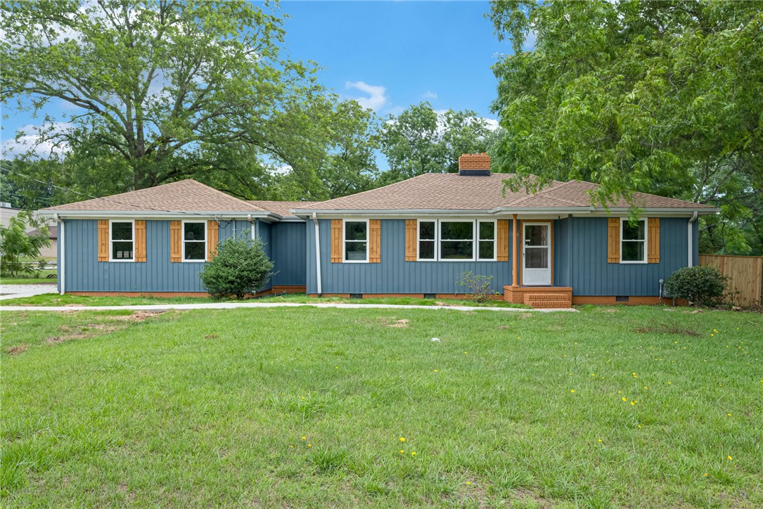 1010 Log Shoals Road Mauldin, SC 29662 - Photo 1 of 28 A classic ranch home showcasing a neat facade with warm wooden shutters, set against a verdant lawn.