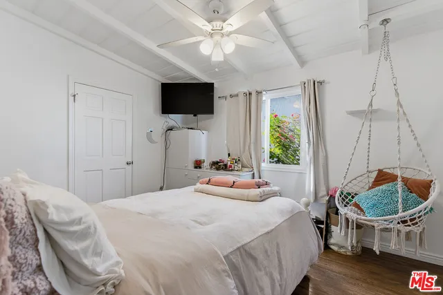 a bedroom with a bed and a flat screen tv