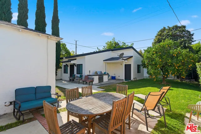 a view of a house with backyard and sitting area