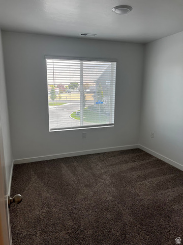 562 Hal Street, Unit 152 Tooele, UT 84074 - Photo 14 of 44 Neutral tone interior featuring a window with horizontal blinds, overhead flush mount lighting, a wall vent, and dark brown carpeting