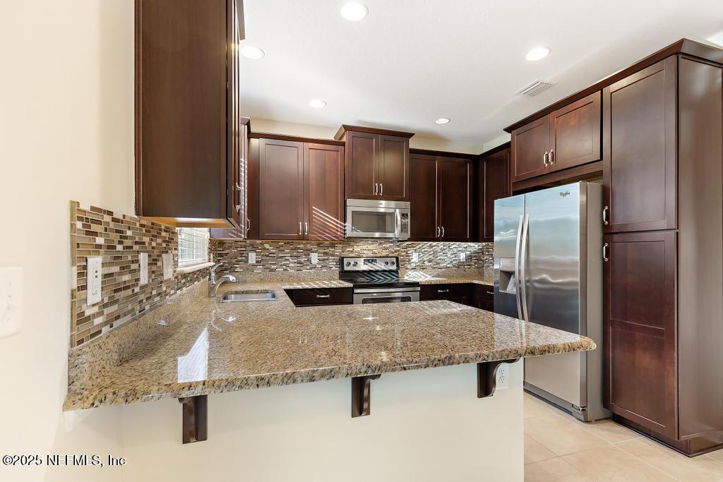 102 San Briso Way St. Augustine, FL 32092 - Photo 17 of 62 a kitchen with kitchen island a counter top space a sink stainless steel appliances and cabinets